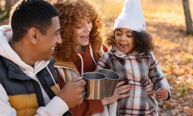 a happy family drinking tea whilst camping