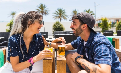 a happy couple having drinks at a beachside lounge