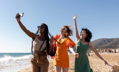 Three woman taking a selfie whilst jumping and smiling