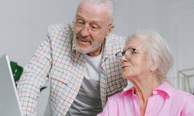 Elderly couple looking at something on a laptop screen