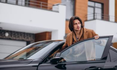 young handsome man sitting into car