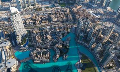 Aerial view of Dubai with Burj Khalifa, skyscrapers, and a turquoise lake