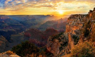 a bright sunrise over the cliffs of the Grand Canyon