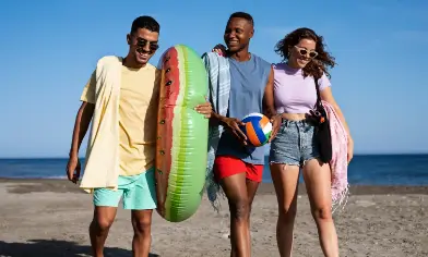 group of friends walking on the beach smiling and being happy