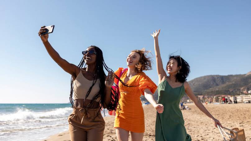 Three woman taking a selfie whilst jumping and smiling