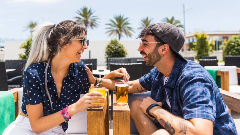 a happy couple having drinks at a beachside lounge