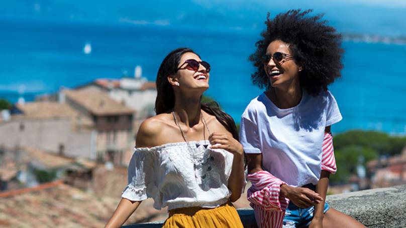 Two persons in a seaside village enjoying the sunshine