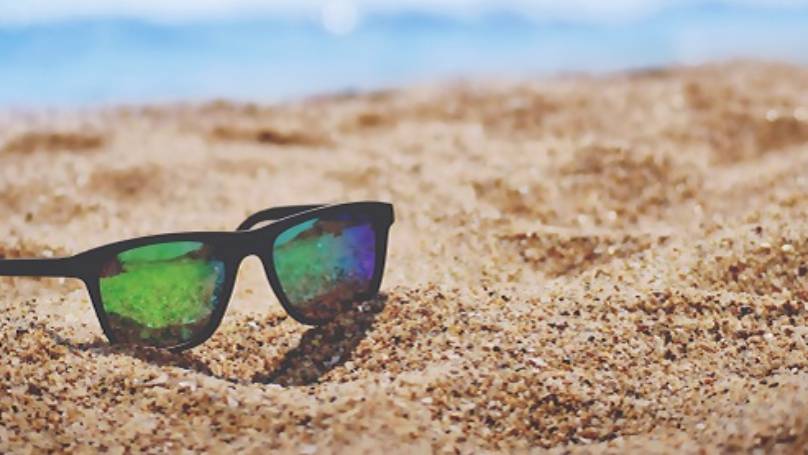 Sunglasses sitting in sand on a beach