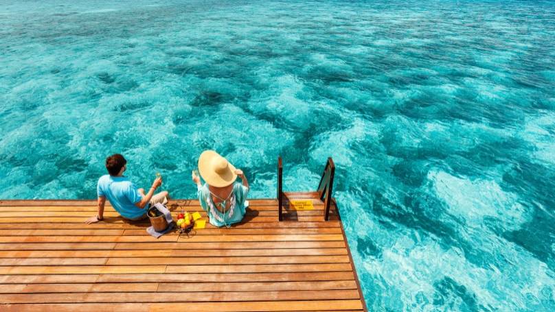 a couple relaxing by the sea with a picnic
