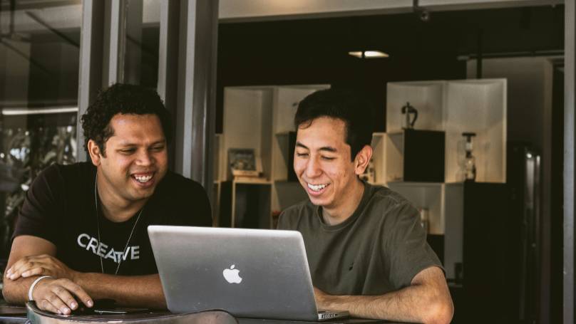 Two individuals engaged in a collaborative work session at a table.
