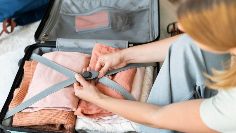 a person packing a suitcase