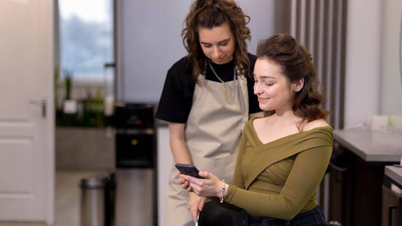 two women looking at a phone together