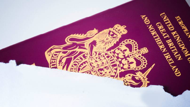 European Union passport poking out of a torn open white envelope