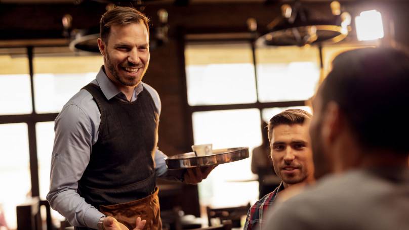 Waiter having a chat with a customer