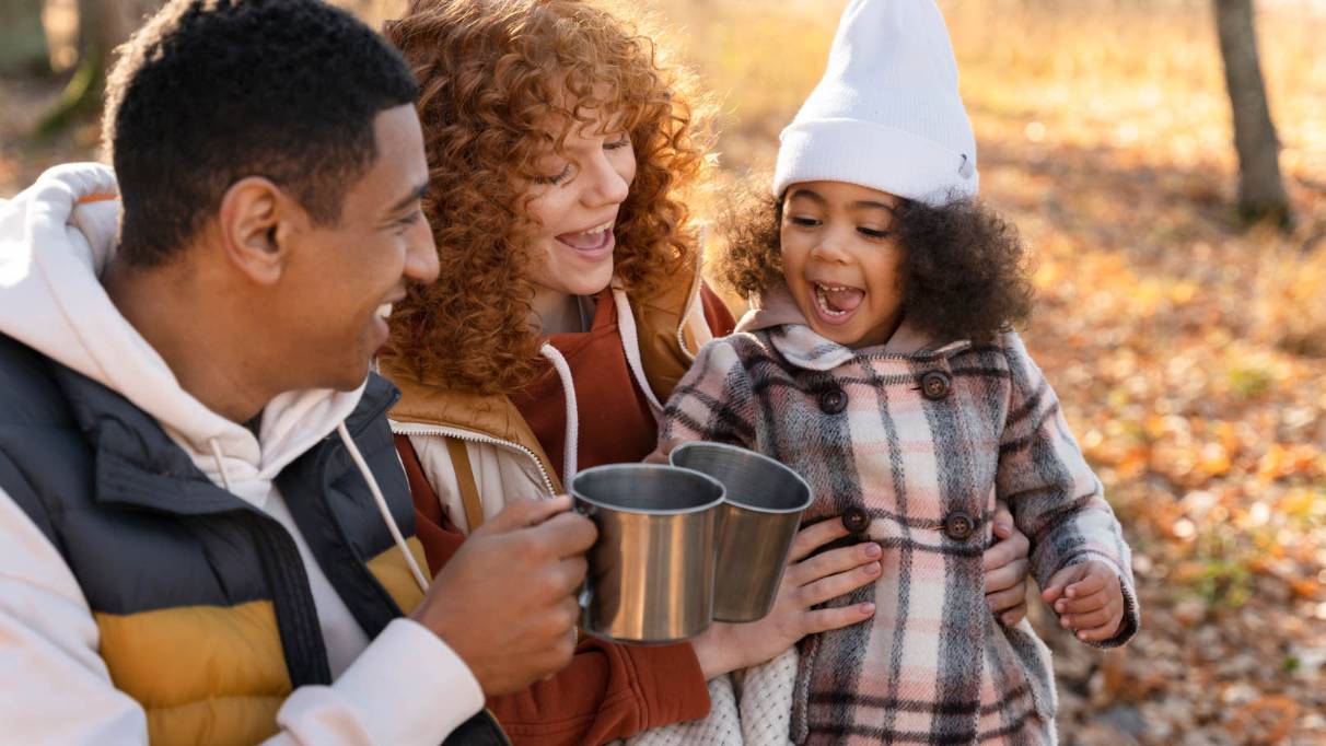 a happy family drinking tea whilst camping