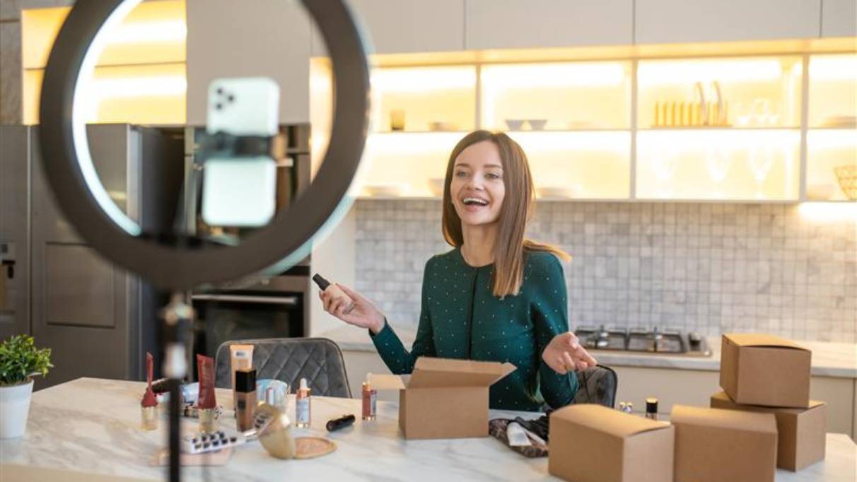 A person filming packing cosmetic products with a ring light for TikTok Shop.