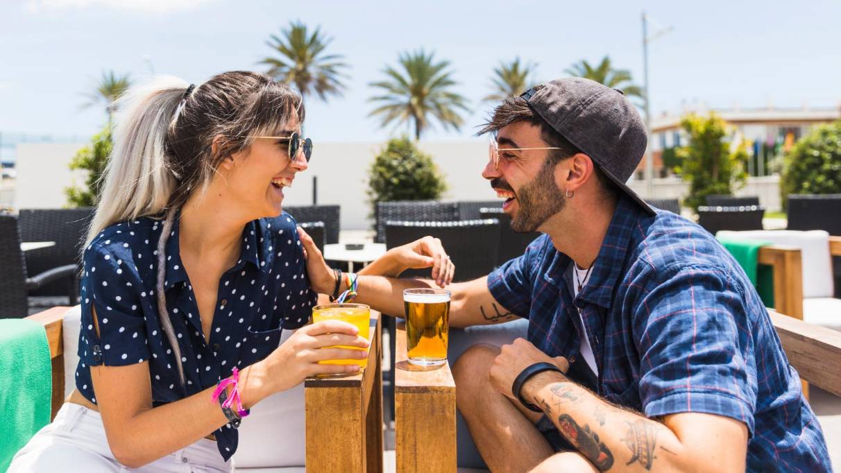 a happy couple having drinks at a beachside lounge