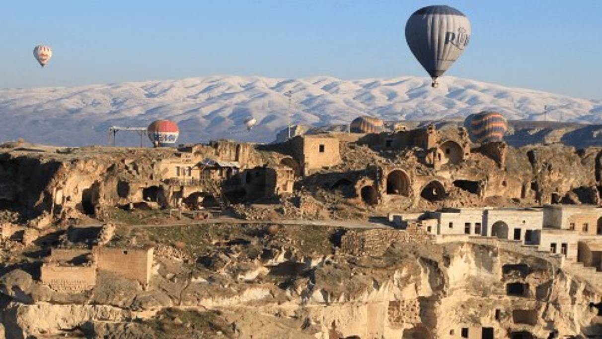 Cappadocia with hot air balloons flying around the sky