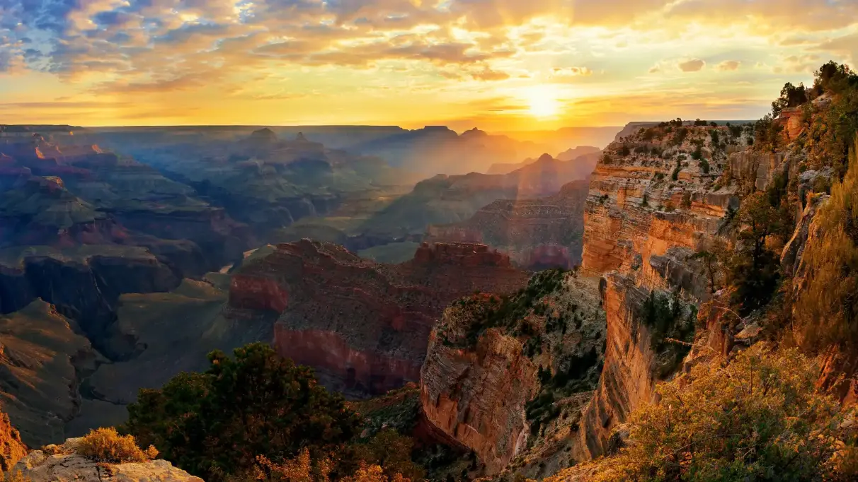 a bright sunrise over the cliffs of the Grand Canyon