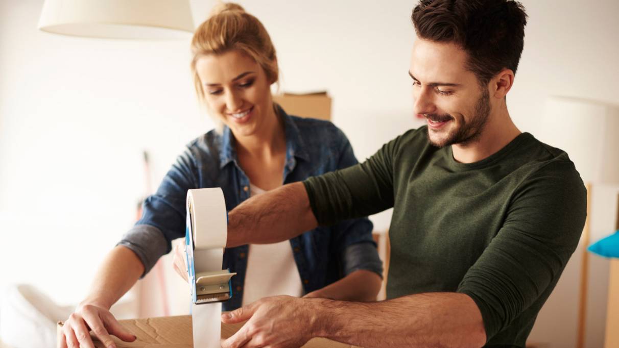 man and lady taping up a box together