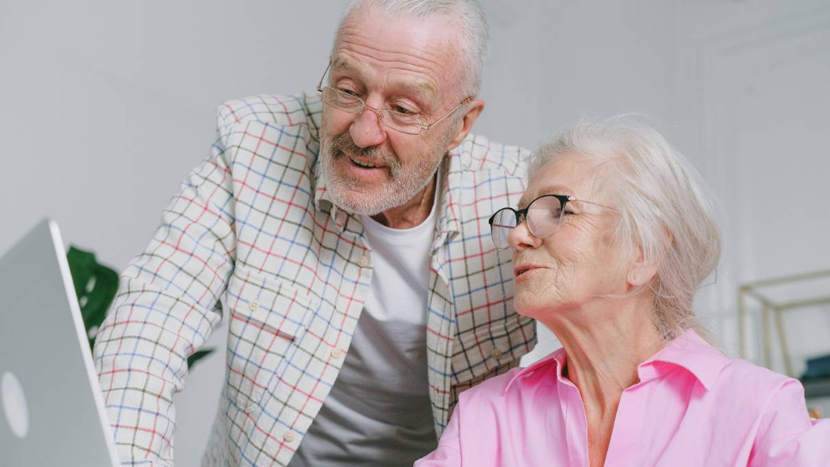 Elderly couple looking at something on a laptop screen
