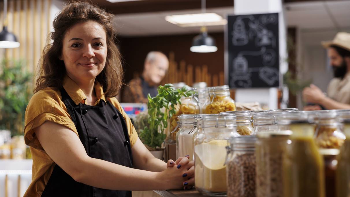 Side view of a man standing at a Post Office branded cash machine outside a branch on a high street