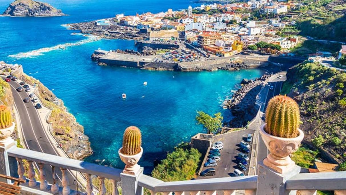 Elevated view of small coastal town in Canary Islands surrounded by blue waters