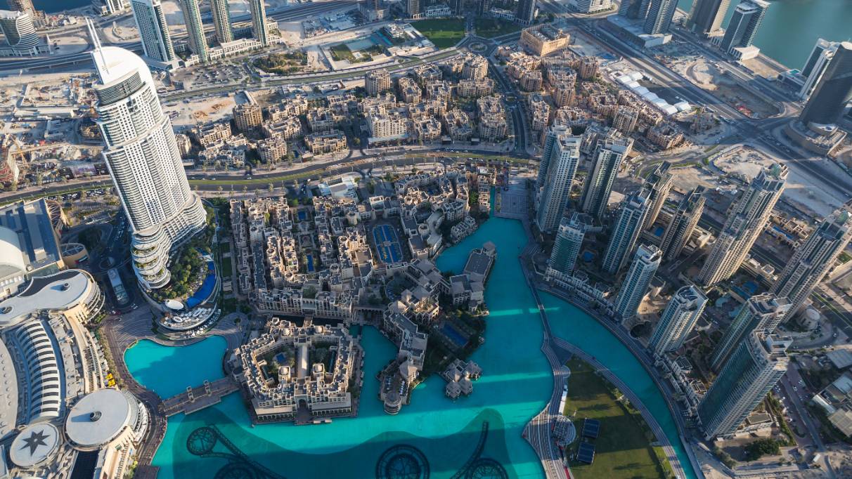 Aerial view of Dubai with Burj Khalifa, skyscrapers, and a turquoise lake