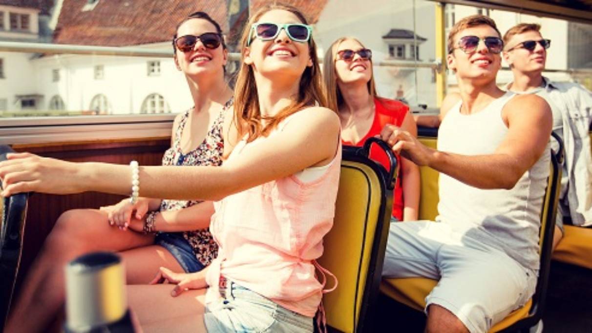 A group of friends on the top deck of a tourist bus