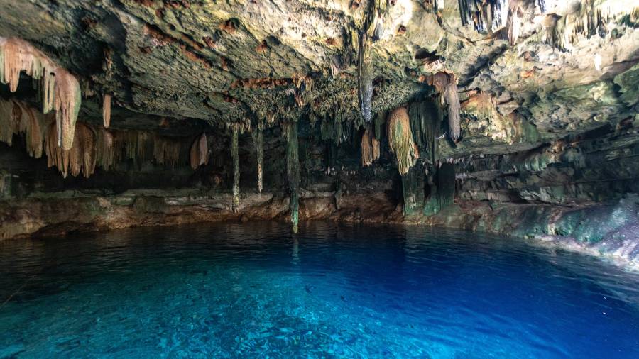 A cave filled with bright blue water