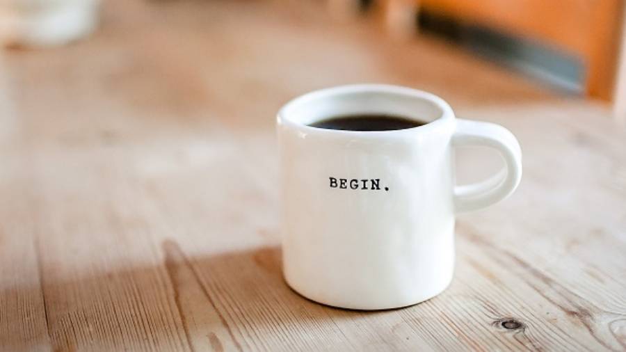 Cup of coffee without milk on a long wooden table