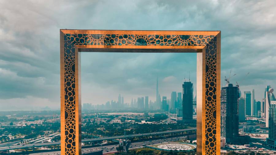 Dubai Frame, a 150m tall, gold-patterned structure, with the city skyline including Burj Khalifa visible through its centre
