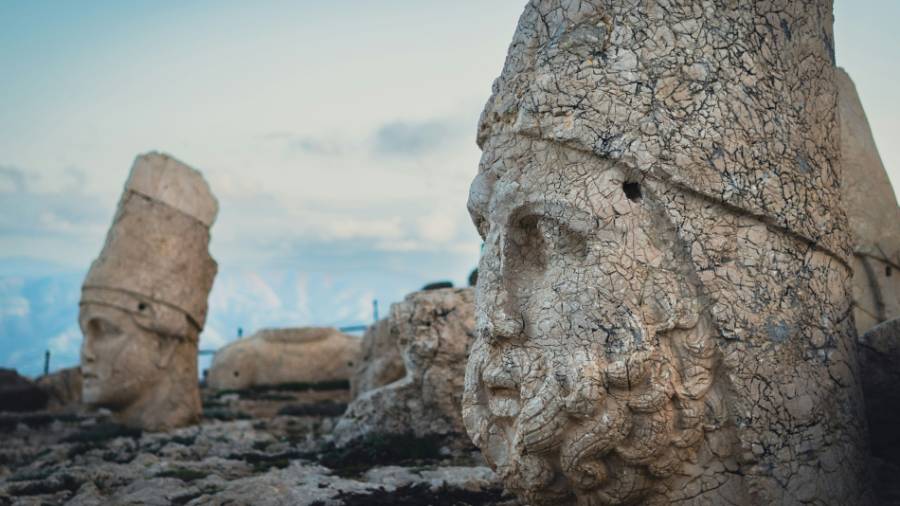 A group of large rocks shaped into heads, each in an ornate headdress 