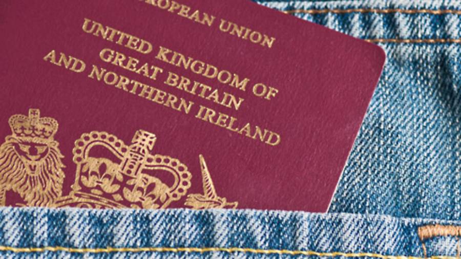 UK passport sticking out of the pocket of a pair of jeans