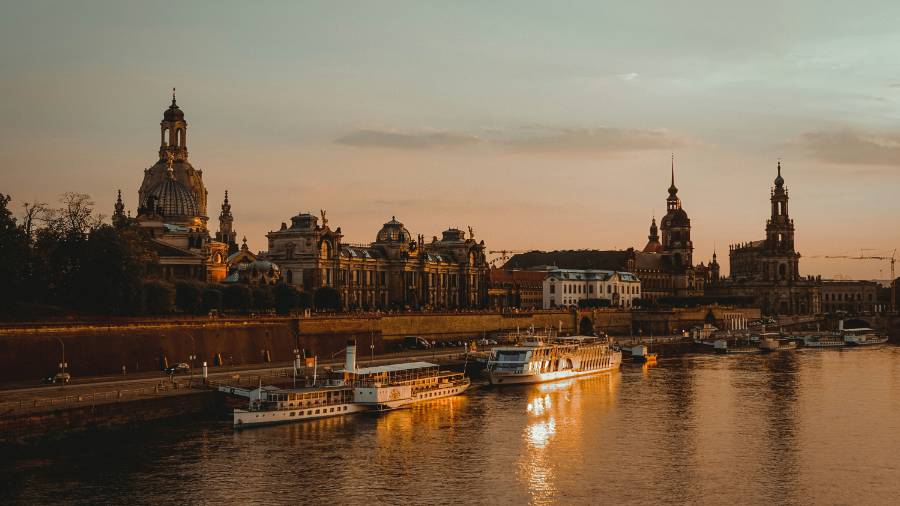 Dresden at sunset, featuring a river, boats and buildings