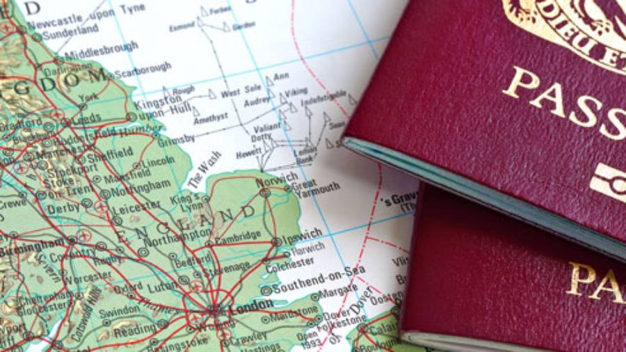 Two biometric passports on top of a map of Great Britain