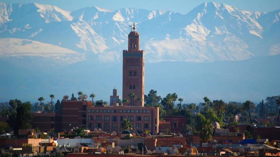 Cityscape of Marrakech on a bright day with mountains behind