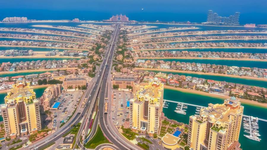 Aerial view of Palm Jumeirah, a palm-shaped island in Dubai with homes and hotels surrounded by the sea