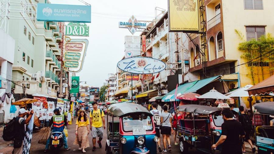 Thailand market with various people walking around and trikes driving around