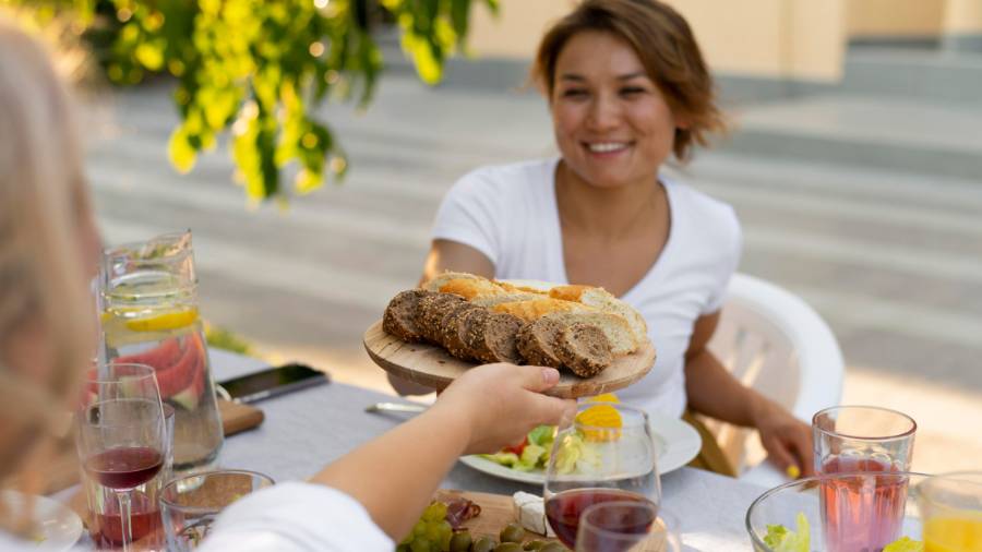 a person handing another a plate of food across a table