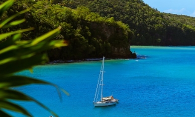Boat on blue waters surrounded by green hillside