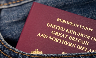 European Union passport partially sticking out of a front pocket of denim clothing