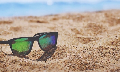 Sunglasses sitting in sand on a beach