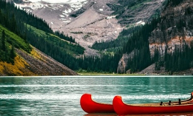 Canadian kayaks in water surrounded by Canadian mountains and trees