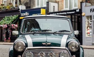 Vintage green mini car in front of High street shops