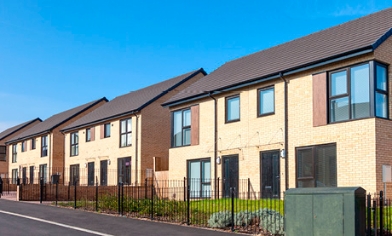 Row of houses on left side of a long road