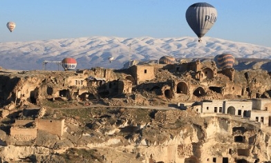 Cappadocia with hot air balloons flying around the sky