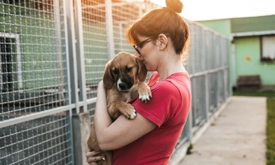 Woman holding her dog in her arms