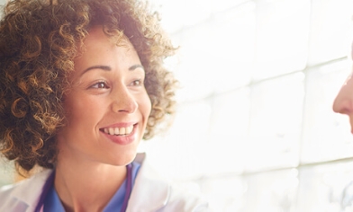 Female doctor smiling and talking to an elderly female patient