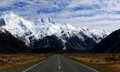 New Zealand road with snow-capped mountains either side and ahead